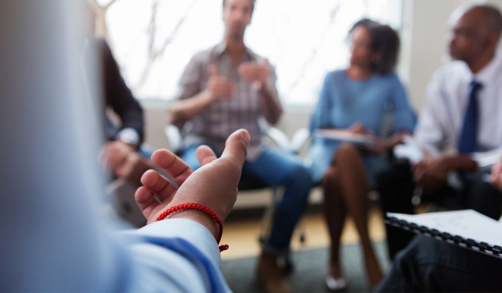 A person leads a small group discussion.